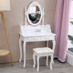 a white dressing table with a mirror and stool