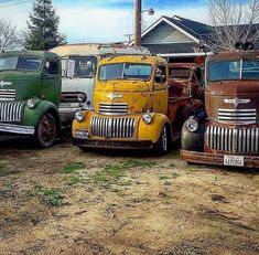 three old trucks parked next to each other