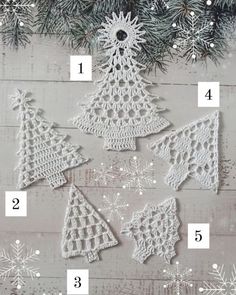 crocheted christmas tree ornaments on a wooden table with snowflakes and pine needles