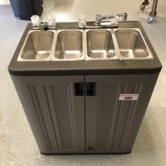 an image of a kitchen sink in the middle of a room with other items on the floor