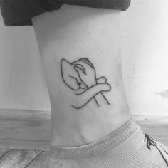 a black and white photo of a woman's foot with a tattoo on it