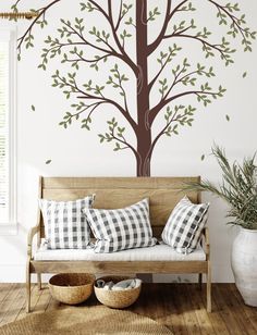 a living room with a couch and tree wall decal