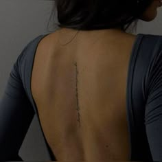 the back of a woman's neck with a tattoo on her left arm and lower back