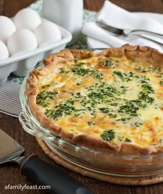 a quiche with broccoli and cheese in a glass dish on a wooden table