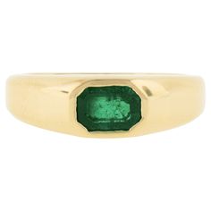 a gold ring with an emerald stone in the center