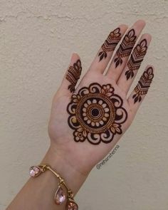 a woman's hand with henna tattoos on it