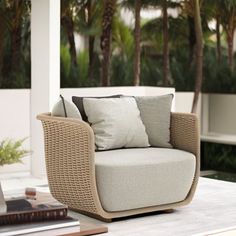 a chair sitting on top of a white table next to a laptop computer and palm trees