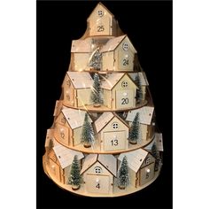 a wooden christmas tree with houses and trees on the top is made out of wood