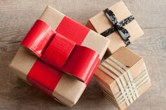 three wrapped presents sitting on top of each other with ribbons tied around the boxes and bows