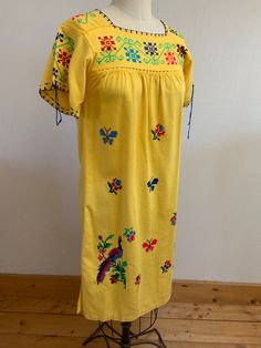 "Beautiful, vibrant yellow cotton dress with bright floral, butterfly, and peacock hand embroidered cross stitch design. So sweet! I'm not sure what to call the gathered decorative stitching that holds each piece to the next but it's beautiful.  Laid flat it measures- Shoulder 14.5\" Pit to pit 15\" Waist 20.5\" Length 40\" Fits like a XS/S Hand wash cold, dry flat Please ask any questions prior to purchase and see all photos, all sales are final, thank you!" Traditional Spring Embroidered Dress, Traditional Spring Embroidered Dress With Machine Embroidery, Yellow Floral Embroidered Dress For Spring, Yellow Bohemian Dress With Floral Embroidery, Yellow Floral Embroidered Dress, Traditional Yellow Embroidered Dress For Spring, Yellow Folk Style Embroidered Dress, Yellow Embroidered Folk Dress, Yellow Folk Dress For Spring