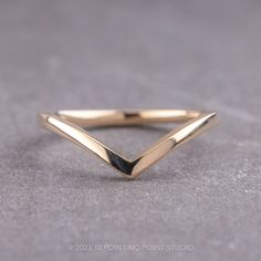 a close up of a gold ring on a gray surface