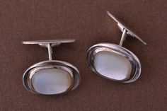 An elegant pair of vintage 1950's cufflinks. 835 silver set with mother-of-pearl. Marked: ''835''. Dimensions: 20mm x 15.6mm x 4.35mm. Weight: 9.56g Condition: Excellent Square Mother Of Pearl Sterling Silver Cufflinks, Formal White Gold Mother Of Pearl Earrings, Elegant Formal Clip-on Cufflinks, Antique Round Cufflinks For Formal Occasions, Modern Sterling Silver Cufflinks For Formal Occasions, Modern Sterling Silver Cufflinks For Formal Wear, Formal Sterling Silver Jewelry With Screw Back, Modernist Oval Jewelry For Formal Occasions, Elegant Polished Cufflinks For Anniversary