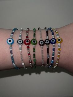 A collection of handmade evil eye bracelets, each one features a different colour of evil eye which comes with its own spiritual meaning.  Each bracelet is approximately 18cm in length however everyones wrists vary in size, so simply let us know under personalization if you need additional length approx how many additional centimeters you require, and chain will be added to ensure a perfect fit.  thank you for visiting my listing and remember to support small businesses🤍 Please note that, as ev Beaded Evil Eye Necklace, Evil Eye Jewelry Bracelet, Evil Eye Beaded Bracelet, Seed Bead Crafts, Eye Bracelets, Handmade Evil Eye, Hippie Bracelets, Hand Bracelet, Spiritual Meaning