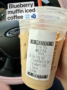 a person holding up a cup of coffee in their hand with a price label on it