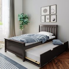 a bedroom with a blue bed frame and white pillows on the bottom, along with pictures above it