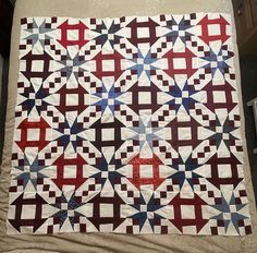 a quilt made with red, white and blue squares