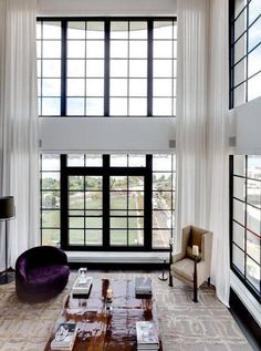 a living room with high ceilings and large windows