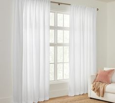 a living room with a white couch and window