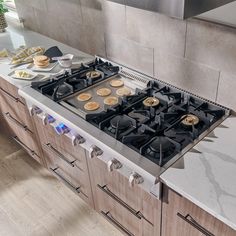 a stove top oven sitting in a kitchen next to a counter with plates on it