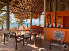 an outdoor bar with chairs and tables on the beach