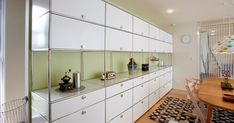 a room with lots of white cupboards and a wooden table in front of it