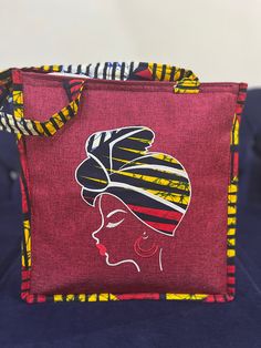 Made by Africa's finest, the cutest most durable tote bag with African print embellishment and embroidery. Whwt makes this bag unique is the fact that this bag is furnished with embroidered images of African beautiful women and embellished with strong vibrant African Print Fabric. This cotton vibrant African Fabric is also used around the rest of the bag which includes the handles.  This tote bag can be used for every day use, to the beach, to lectures, brunch afternoons, church, work. It can fi Large Capacity Fabric Bags, Fabric Canvas Bag For Shopping, Pink Lunch Bag For Daily Use, Red Square Canvas Bag For Daily Use, Red Canvas Shopping Bag, Square Large Capacity Lunch Bag For Gift, Gift Large Capacity Square Lunch Bag, Handmade Red Canvas Tote Bag, Pink Square Canvas Bag