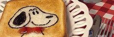 a toasted sandwich with a dog on it is sitting on a plate next to utensils