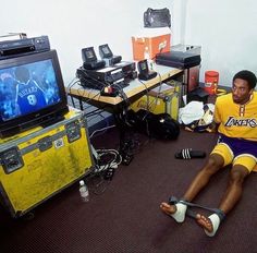 a young man sitting on the floor in front of a tv playing video games with his feet up