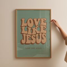 a woman holding up a poster with the words love like jesus