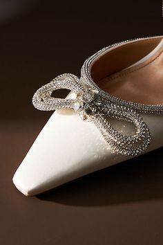 a pair of white high heeled shoes sitting on top of a table