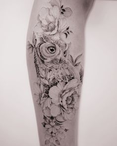 an owl and flowers tattoo on the right thigh, which is also in black and white