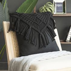 a black pillow sitting on top of a wooden chair