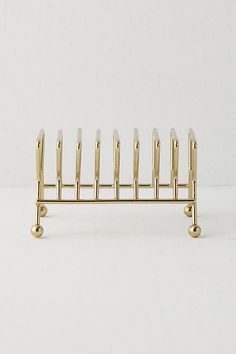 a gold metal rack with several candles on it's sides and one candle holder in the middle