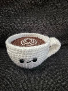 a crocheted coffee cup sitting on top of a couch