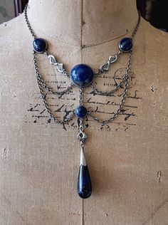 Featuring an absolutely gorgeous antique c.1900s Bohemian Arts and Crafts Jugendstil Art Nouveau solid sterling silver ornate festoon necklace adorned with beautiful marbled Sodalite stones set in open back settings.  Necklace measures approximately 16 inches around with a 3 inch pendant drop at 28.2 grams respectively.  This rare turn of the century festoon is in excellent antique condition with a functional antique thumbless clasp, a beautiful patina with all stones intact and accounted for.  Stamped STERLING on the reverse of center stone, don't miss this gorgeous beautifully handcrafted antique necklace! Please feel free to contact me with any questions or suggestions I'm always learning (Box not included) Silver Art Nouveau Jewelry For Ceremonial Occasions, Art Nouveau Silver Jewelry For Ceremonial Occasions, Victorian Antique Finish Collectible Necklace, Antique Blue Necklace With Intricate Design, Antique Silver Necklace With Historical Design, Silver Necklace With Intricate Art Nouveau Design, Collectible Ornate Jewelry With Historical Design, Antique Blue Jewelry For Ceremonial Occasions, Collectible Victorian Jewelry With Historical Design