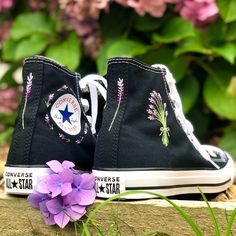 These custom Converse trainers are embroidered by hand with beautiful purple lavender flowers.  I offer the option to chose how much embroidery you would like on the shoes which all vary in price.  - The 'logo embroidery' option if for the ring of lavender that surrounds the logo on the inside of each shoe.  - The 'lavender bouquet' option is just for the bouquet of lavender which is embroidered on the outside of each shoe.  - The 'all over embroidery' option is for the logo embroidery, bouquet embroidery, and the lavender flower which is embroidered on the back of each shoe.  The embroidery is done in high quality cotton thread to create a completely unique pair of shoes.   I only purchase 100% genuine shoes from the official converse website. Sizes are in standard woman UK sizes. **Becau High-top Cotton Sneakers With Floral Embroidery, Spring High-top Sneakers With Embroidered Logo, High-top Sneakers With Embroidered Graphics For Spring, Casual Sneakers With Custom Embroidery For Spring, Black High-top Sneakers With Floral Embroidery, Spring Embroidered High-top Sneakers, Casual High-top Sneakers With Custom Embroidery, Summer High-top Sneakers With Floral Embroidery, Summer Embroidered High-top Sneakers