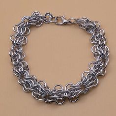 a silver chain bracelet on a tan background