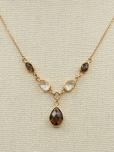 Gold:  9ct Weight:  3.1 grams Gemstone:  Smoky quartz, Rock quartz Size:  16 inches to 18 inches Condition:  Excellent Vintage Condition A beautiful vintage 9ct gold smoky and rock quartz drop necklace. It features 5 faceted quartz gemstones in a Y shape.  It's lightweight, impactful and catches the eye.  The gems are in excellent condition and sparkle under the light.  The chain is adjustable from 16 inches to 18 inches to allow for different necklines.  The largest quartz stone is 10mmx 8mm. T Luxury Brown Gemstone Necklace, Pirate Core, Different Necklines, Smoky Quartz Necklace, Quartz Rock, Quartz Gemstones, Wedding Jewellery Necklace, Stone Gold, Quartz Necklace