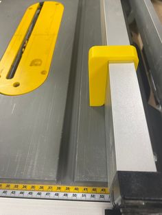 a machine that is cutting metal with a ruler on the table next to it,