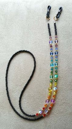 "This chain is done with all the beautiful colors of the rainbow. it is done with swarovski crystals and czech glass rainbow beads with goldplated spacer beads with black jet seed beads for the main chain, very beautiful look.it is approx 29\" long. if you would like a different length, email me right after buying or put it in the notes of paypal payment. it is strung on 49 strands of nylon coated wire, the strongest most flexible non kinking material available. check out my other listings as i Eyeglass Jewelry, Eyeglass Chain Holders, Eyeglass Necklace, Glasses Strap, Black Jet, Glass Balls, Sunglass Chain, Rainbow Glass, Beaded Lanyards