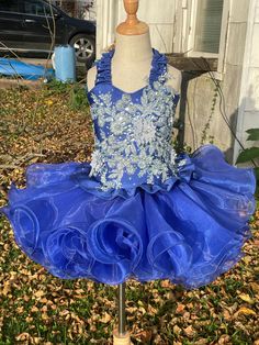 Beautiful blue glitz cupcake dress. Fits size 6-8. Features a corset back, elastic waistband on skirt and magnetic snaps to help hold the two together to prevent gapping. The top has a beautiful elastic ruffle halter with rhinestones along the edge, beautiful light blue appliqué flowers and rhinestones in the middle and a cute ruffle along the bottom. The skirt features an elastic waistband and plenty of layers of ruffles to give it the poof and pizazz that all dresses like this need. This is a Elegant Fitted Ruffle Dress For Dress-up Occasions, Summer Pageant Dress With Fitted Bodice, Fitted Blue Pageant Dress For Dress-up, Blue Embellished Dress For Pageant, Summer Fitted Pageant Dress With Ruffles, Fitted Summer Pageant Dress With Ruffles, Sleeveless Fitted Pageant Dress For Summer, Blue Ruffle Dress With Ruffled Skirt And Straps, Royal Blue Fitted Dress For Pageant