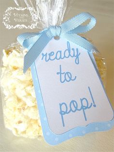 a bag of popcorn with the words ready to pop on it and a blue ribbon