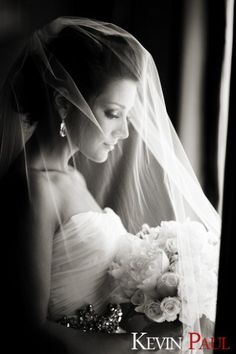 black and white photograph of a bride in her wedding dress with veil over her head