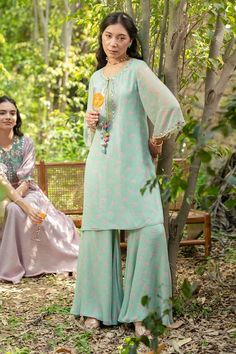 Green tunic crafted from georgette lurex fabric, highlighted with intricate mirror and thread work detailing. Paired with a flared pant. - Aza Fashions Summer Festive Georgette Sets, Eid Tunic Sets With Mirror Work, Spring Straight Kurta Set With Gota Work, Spring Sets With Gota Work And Straight Kurta, Spring Georgette Dress With Mirror Work, Eid Floral Embroidered Sharara, Eid Floral Embroidery Sharara, Straight Kurta Pant Set With Resham Embroidery, Green Sharara With Chikankari Embroidery For Summer