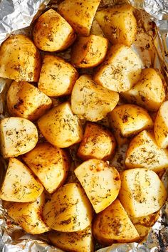 cooked potatoes in foil with herbs and seasoning on top, ready to be eaten