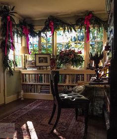 a living room filled with lots of furniture and bookshelves covered in christmas decorations