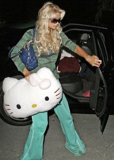 a woman in hello kitty costume getting out of her car