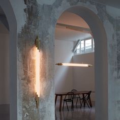 an archway leading into a dining room with a table and chairs in the background,