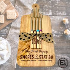 a cutting board with marshmallows on it and the words smores station