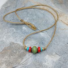 A great choker necklace with a casual minimalist style. Made with a green Czech bead surrounded by red, turquoise and brass beads, it has a simple boho or surfer look.  The Cord is polyester and is long lasting and strong.  The clasp is a simple gold tone hook clasp. A perfect necklace for layering. Length - Choose your length from 14 inches to 17 inches.  You can add a 2 inch extender chain if desired.  If you would like another length please contact me. Thank you! See more of my items here: ht Casual Minimalist Style, Surfer Look, String Necklace, Festival Necklace, Layered Chokers, Brass Beads, Red Turquoise, Necklace Minimalist, Beaded Choker Necklace